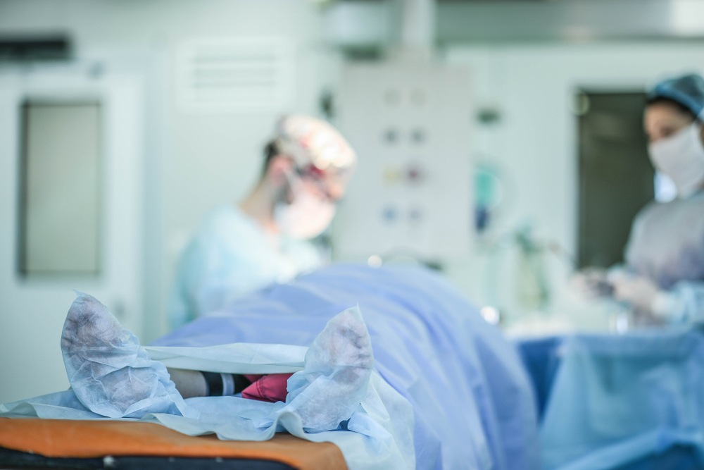 Surgical team in an operating room preparing for a procedure on a draped patient