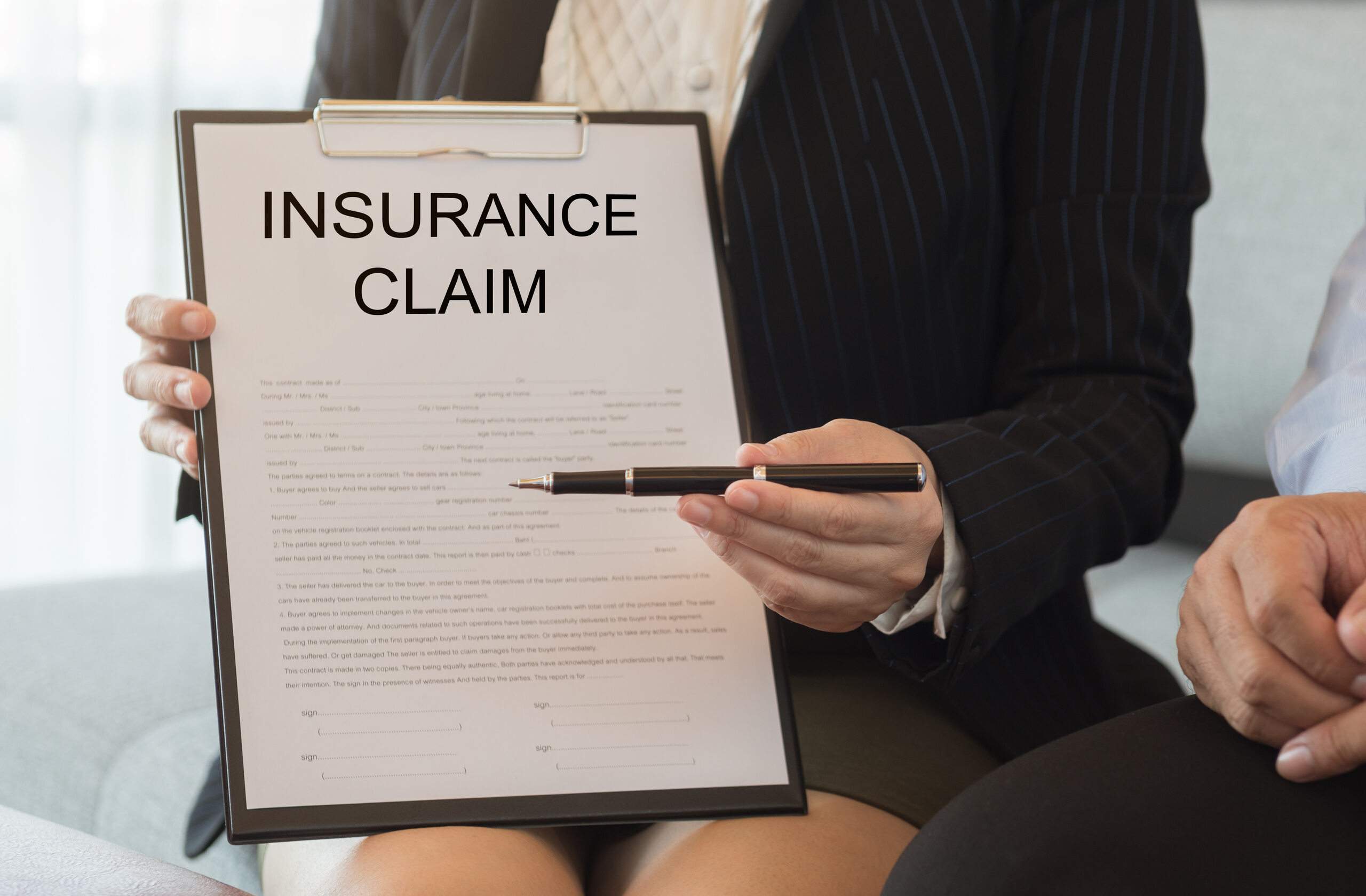 Insurance claim paperwork presented during a settlement review, highlighting how insurance adjusters minimize your claim in Oklahoma.