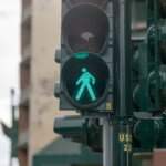 Green walk signal at a city intersection, showing pedestrian right-of-way after an accident in Tulsa