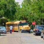School bus accident at a city intersection with police officers and pedestrians, illustrating school bus accident liability in Oklahoma