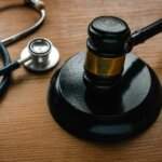 Personal injury lawyer reviewing medical malpractice evidence with a gavel and stethoscope, illustrating when to hire a personal injury lawyer in Oklahoma.