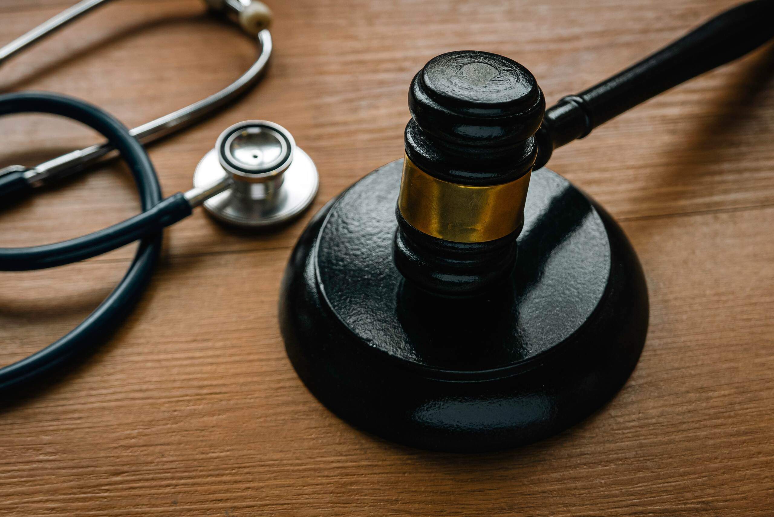 Personal injury lawyer reviewing medical malpractice evidence with a gavel and stethoscope, illustrating when to hire a personal injury lawyer in Oklahoma.
