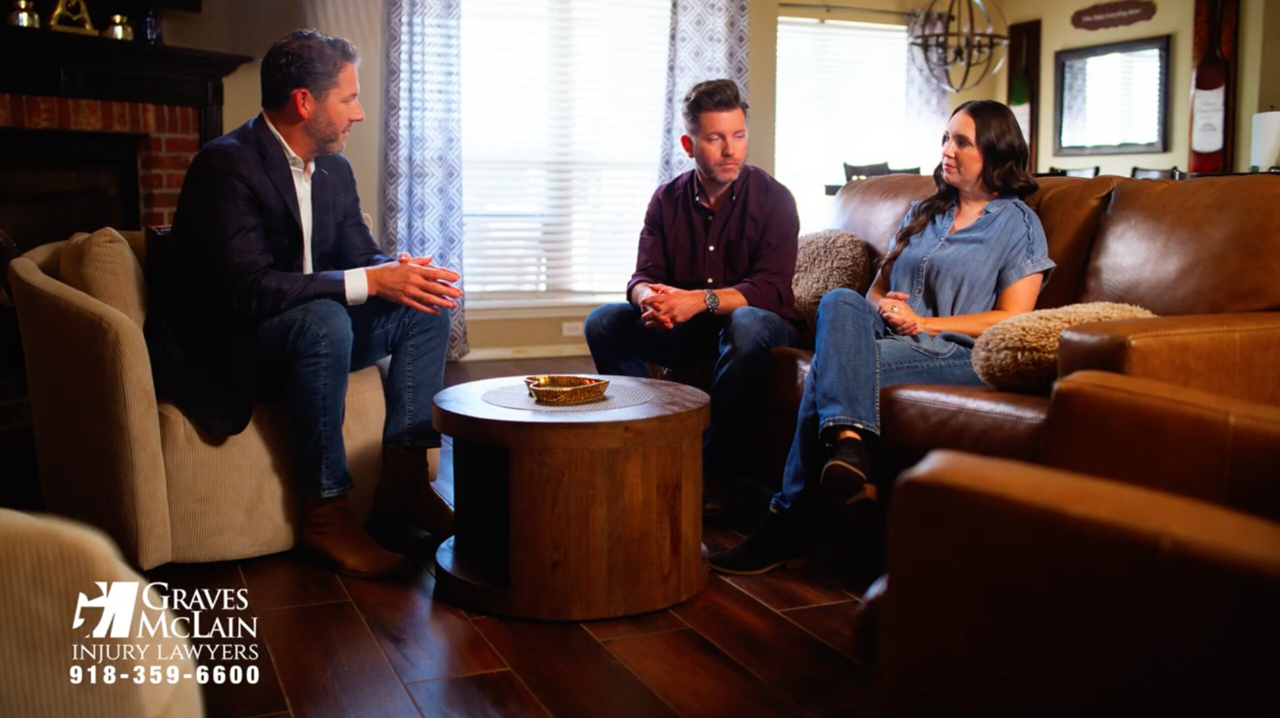 A personal injury lawyer in Tulsa meeting with a couple in their home to discuss a legal claim.