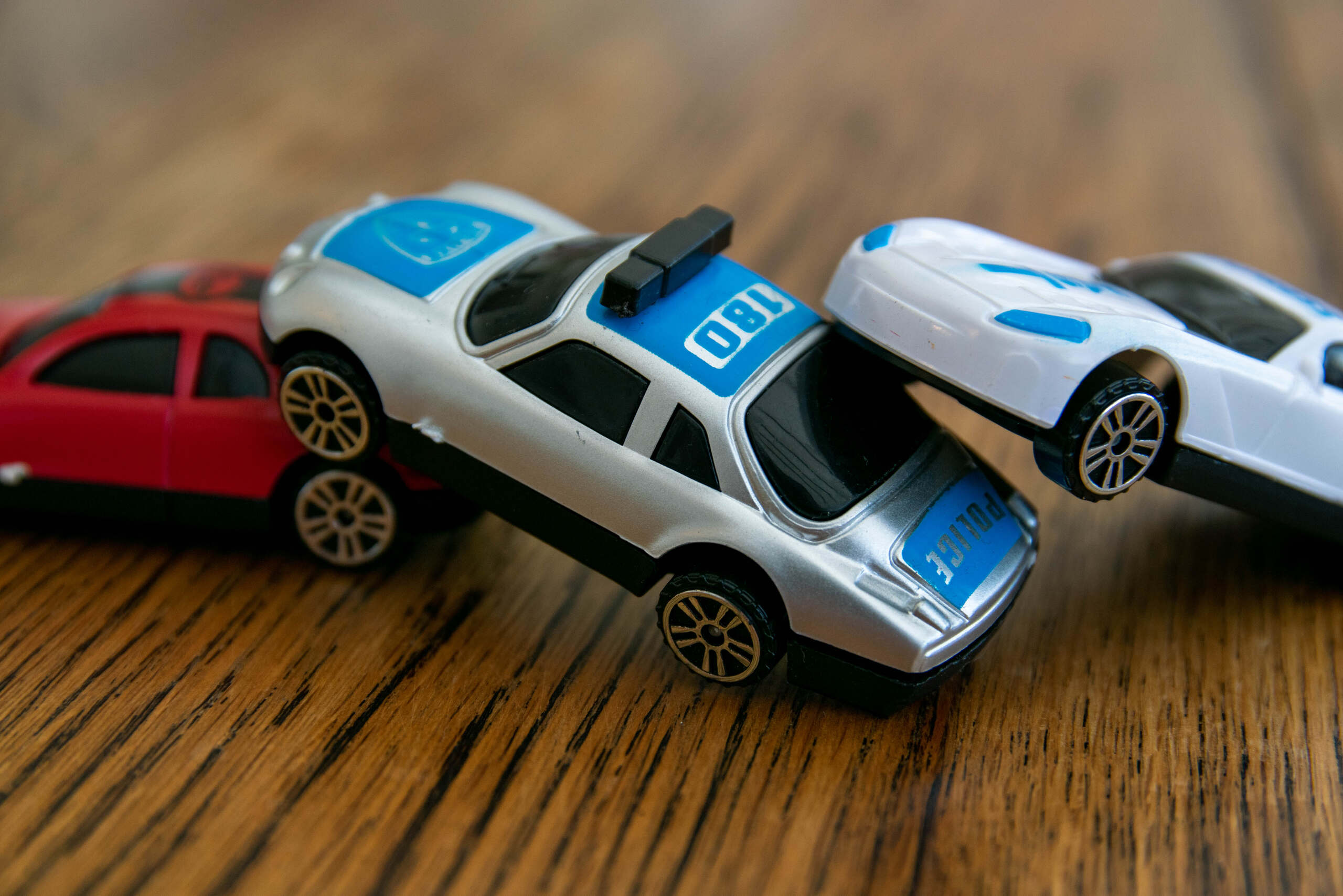 Toy cars in a chain-reaction collision, representing the investigation of fault in an I-44 multi-car pileup under Oklahoma’s modified comparative negligence rule.