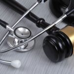 A stethoscope resting next to a legal gavel, symbolizing the intersection of medicine and law in an Oklahoma medical malpractice case.