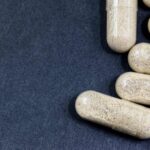 Several prescription capsules on a dark surface, representing a Tulsa drug injury claim.