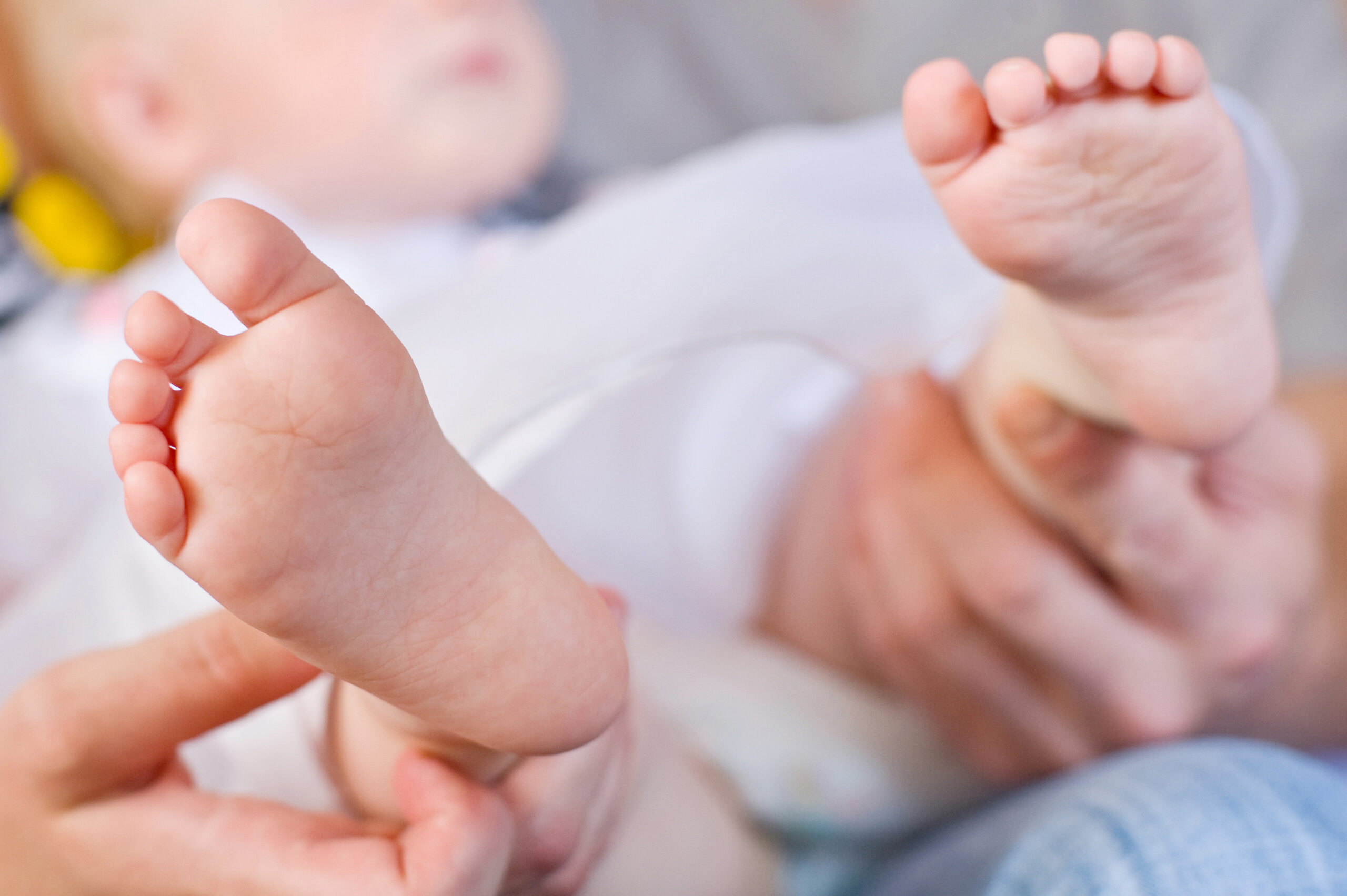 Parent gently holding a newborn baby's feet.