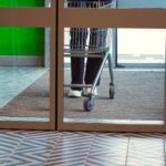 Customer pushing a shopping cart through glass doors, highlighting key factors in proving actual notice for slip and fall injuries in Oklahoma retail stores.
