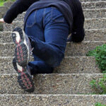 Person tripping on outdoor concrete stairs asking who is responsible when you're injured on someone else's Oklahoma property.